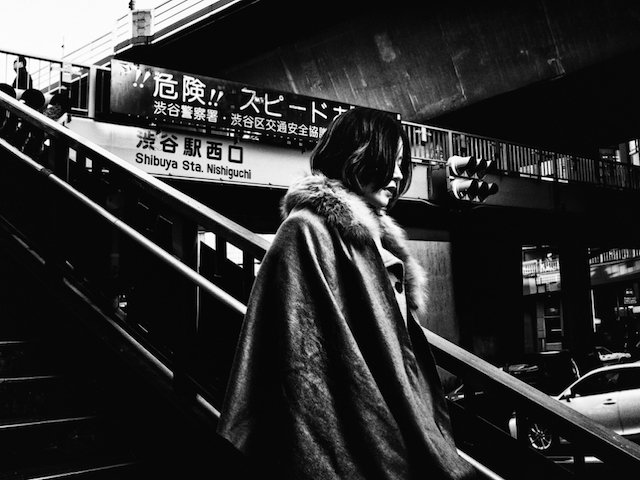 contraste photographique d'une femme en fourrure descendant les marches à Tokyo