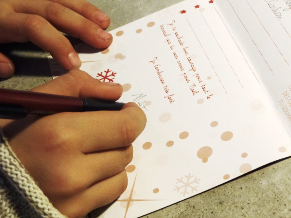 enfant écrivant sa lettre au papa noel