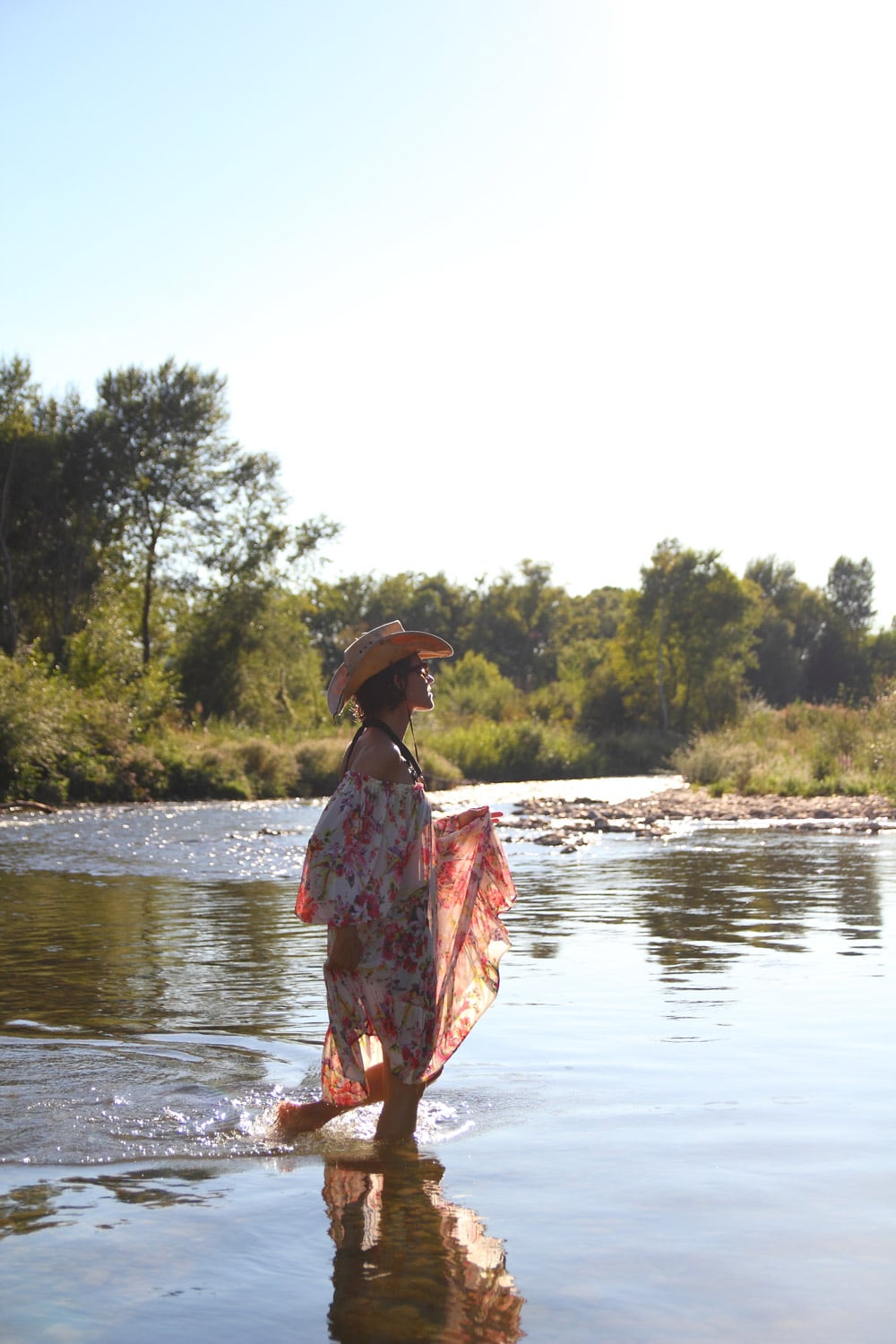 femme marchant dans l'eau en robe fleurie mode