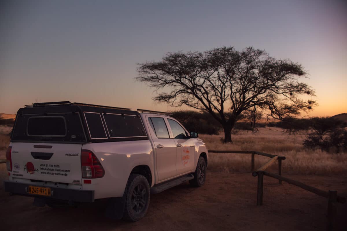 4×4 et campement installés dans la plaine désertique en Namibie