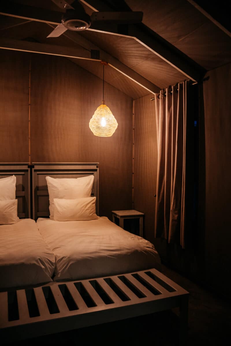Lit dans une tente de glamping éclairée à la lampe