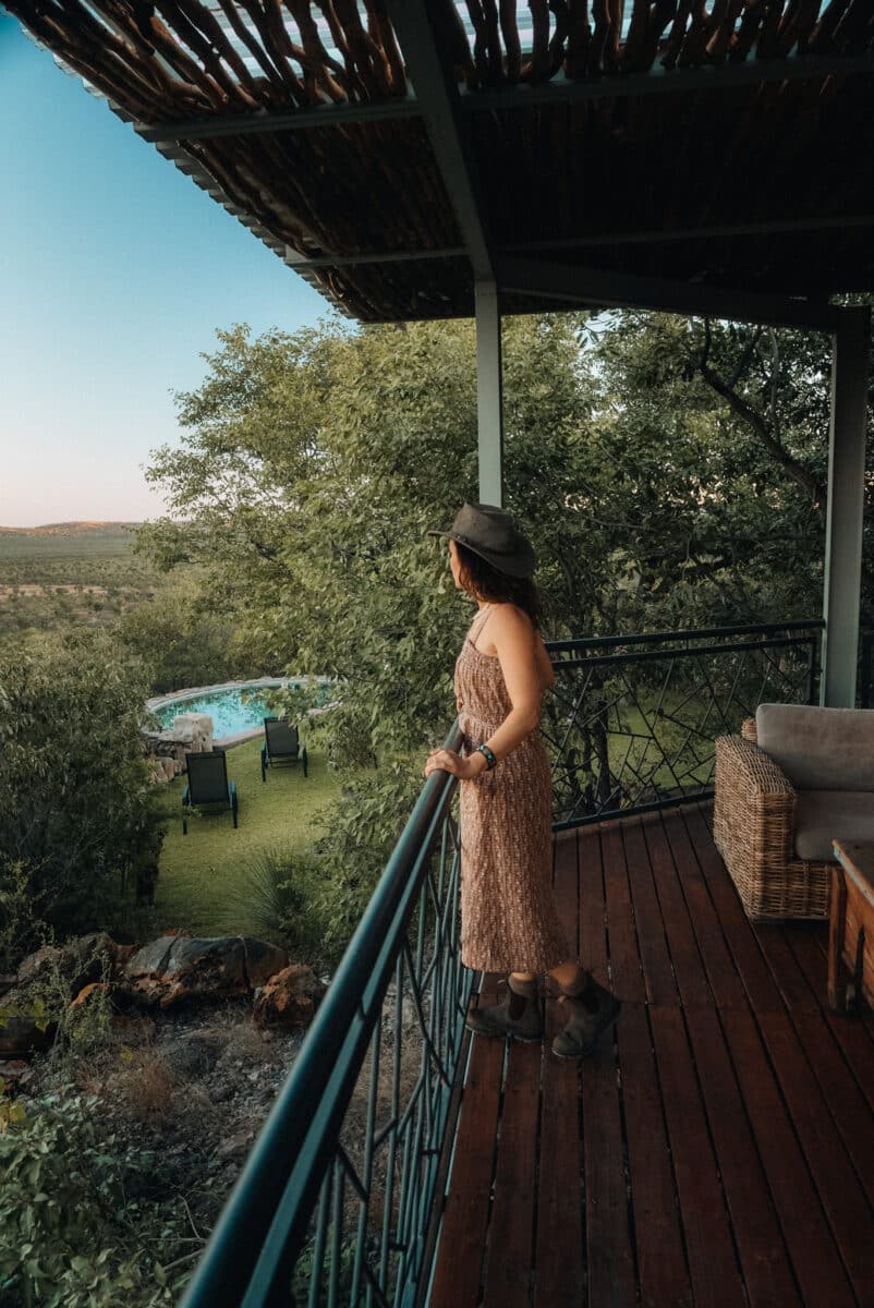 Femme contemplant la savane namibienne depuis la terrasse d'un lodge