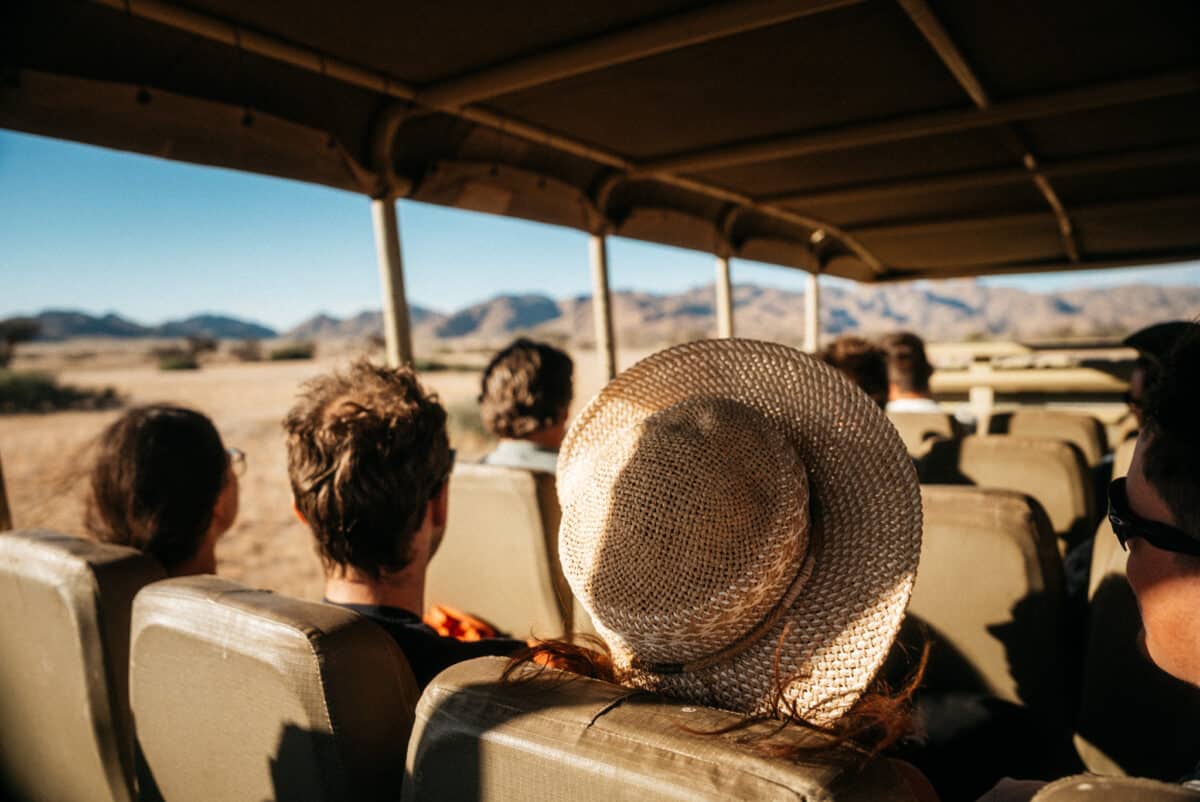 Passagers au chapeau à bord d'un véhicule de safari en Namibie