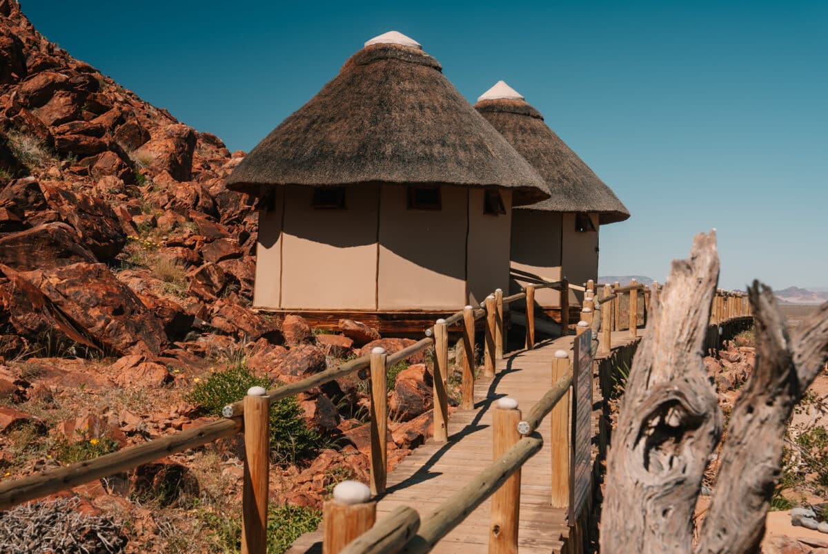 Bungalows au toit de chaume devant une montagne dans le désert