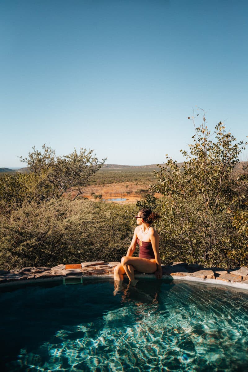 Femme dans une piscine à débordement surplombant la savane