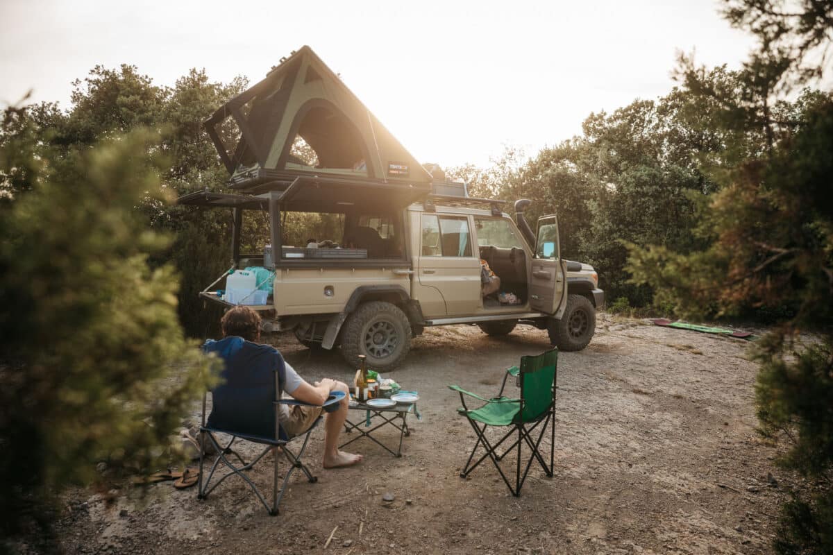 4x4 et tente de toit installés pour la nuit face à une vallée catalane au coucher du soleil