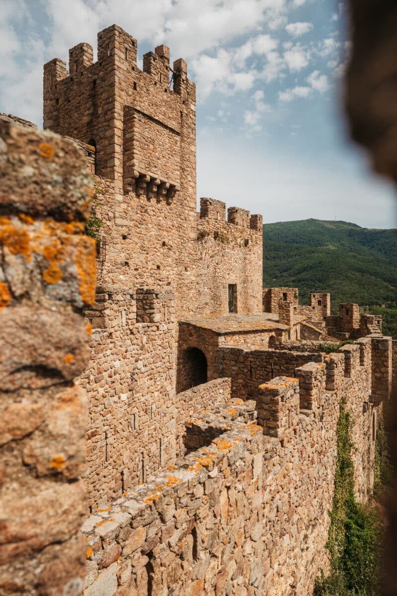 Tours crénelées du château de Requesens vues en contre-plongée depuis le pied des remparts