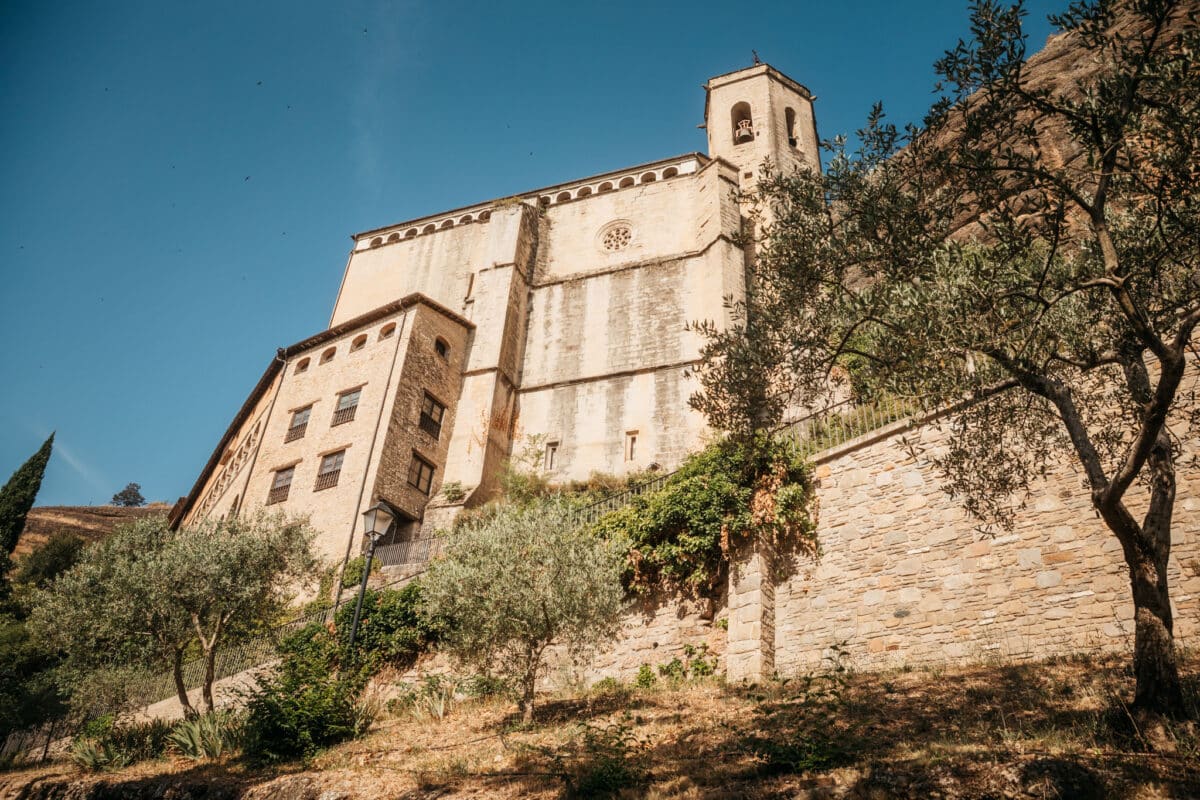 Basilique Virgen de la Peña vue en contre-plongée sous sa falaise à Graus