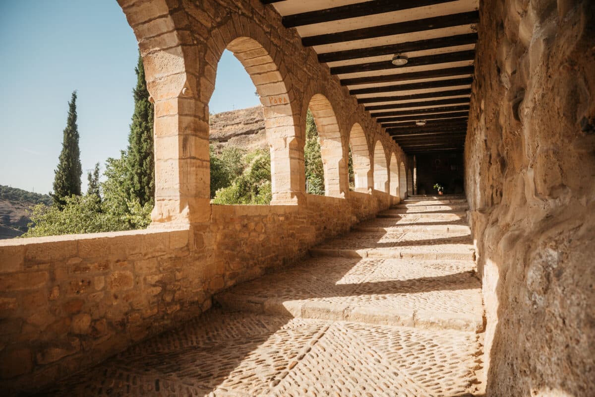 Arcades de pierre de la basilique Virgen de la Peña accrochée à la falaise au-dessus de Graus