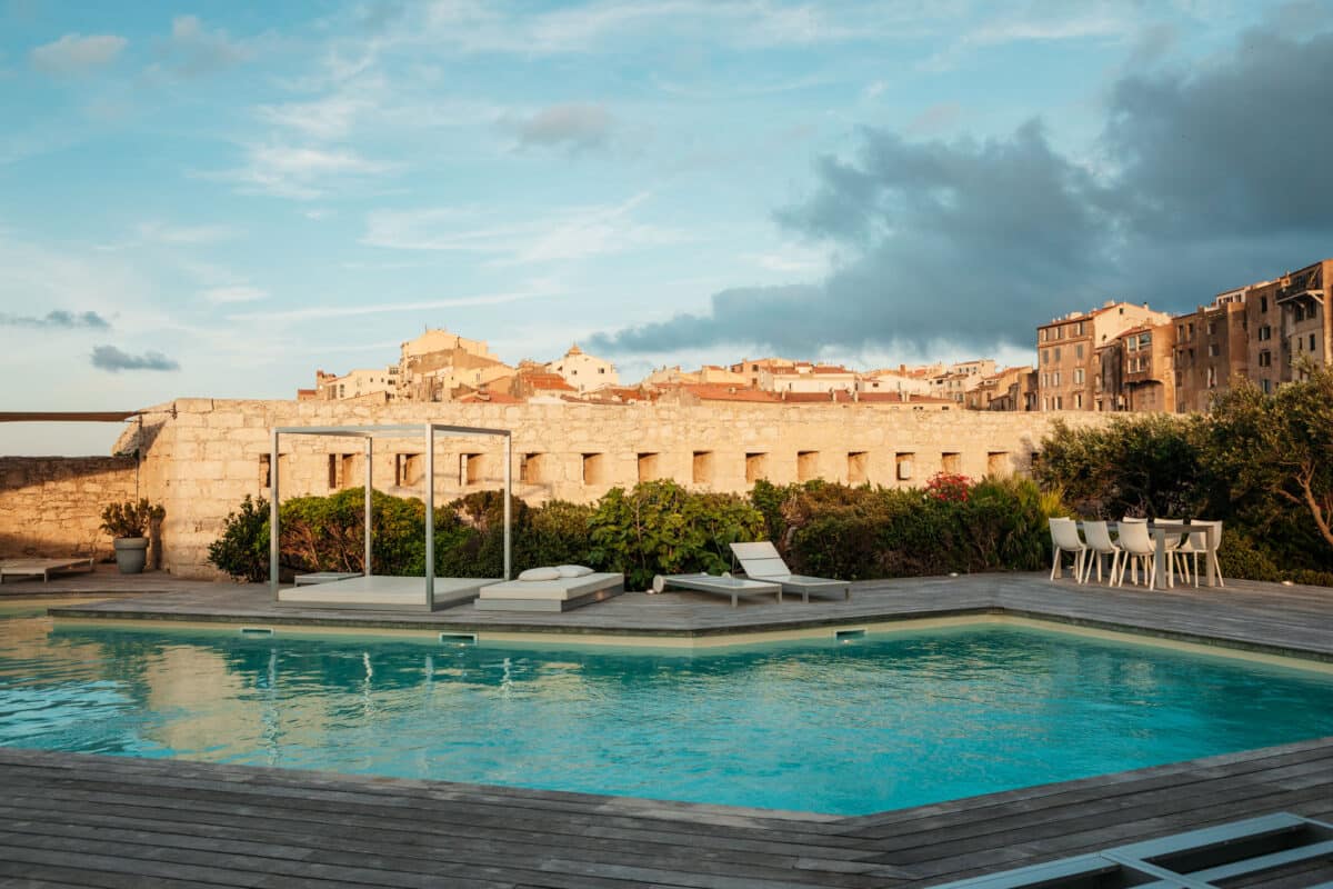 Piscine et transats d'un hôtel avec vue sur la citadelle de Bonifacio