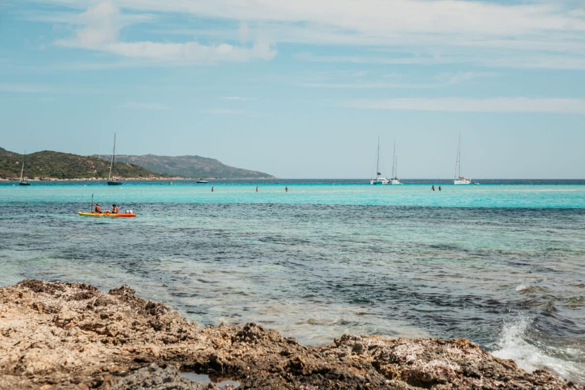 Traversée à pied dans l'eau entre la plage de Piantarella et l'île Piana à Bonifacio
