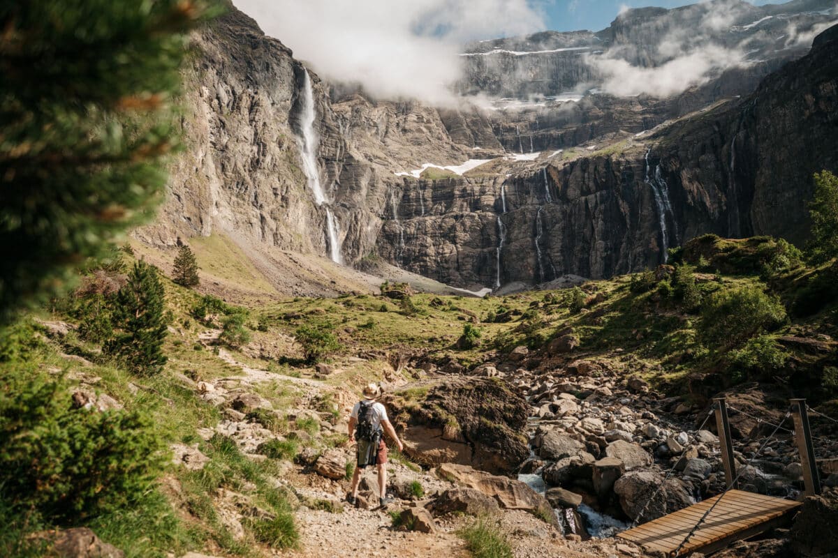 Randonneur face à la grande cascade du cirque de Gavarnie dans les Pyrénées