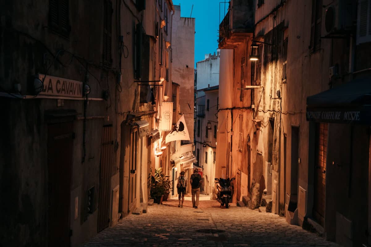 Ruelle pavée de la haute ville de Bonifacio illuminée à la tombée de la nuit