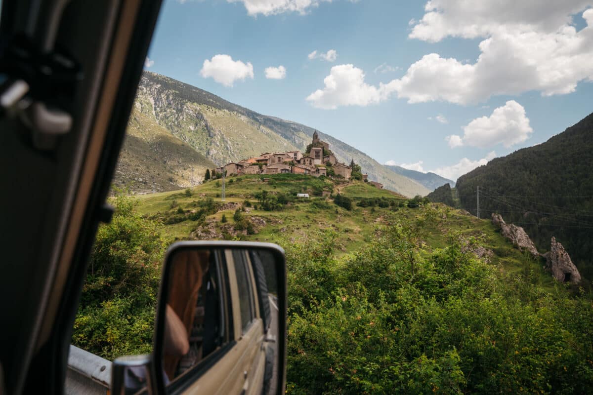Village de pierre en aperçu depuis la route au fond d'une vallée du Cadí-Moixeró
