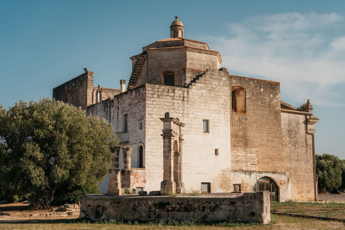 Petite église isolée au milieu des oliviers, vue depuis la route en Vespa