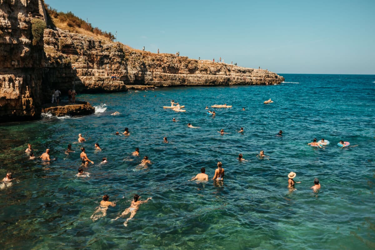 Baigneurs dans l'eau turquoise de Polignano a Mare