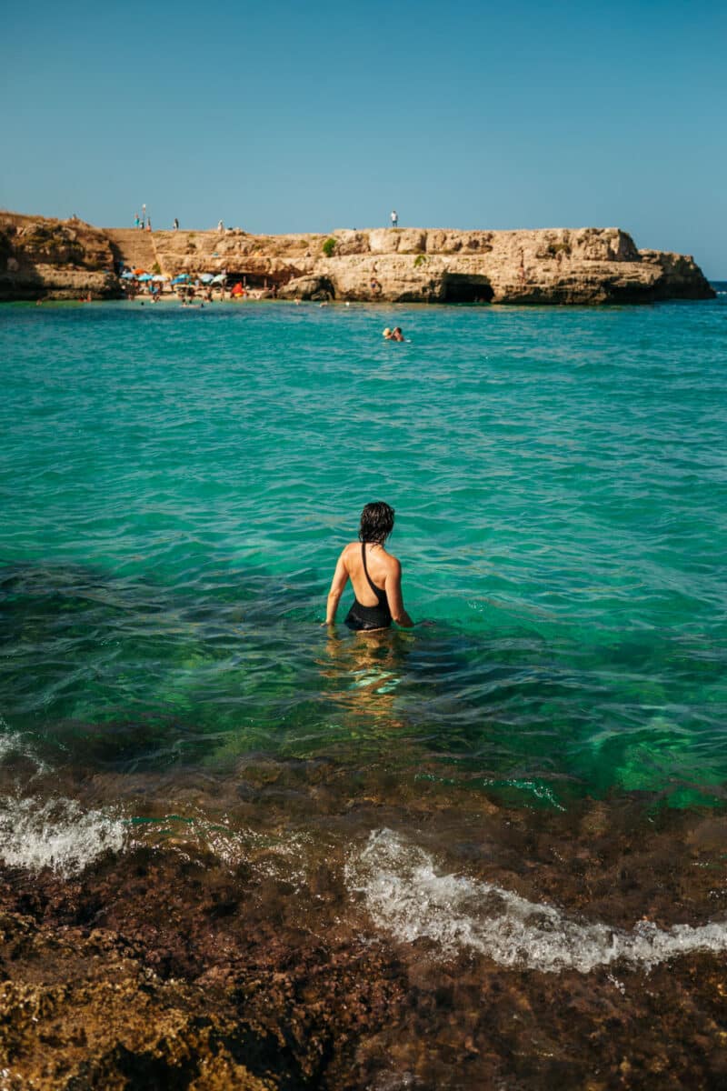 Petite cavité dans la roche où des baigneurs s'abritent du soleil près de Monopoli