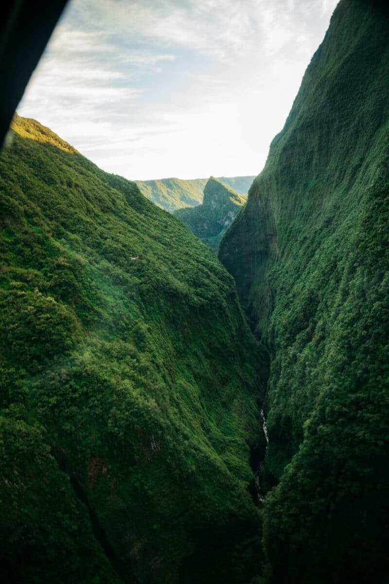 Vallées et crêtes couvertes de forêt au centre de La Réunion, vues depuis un hélicoptère