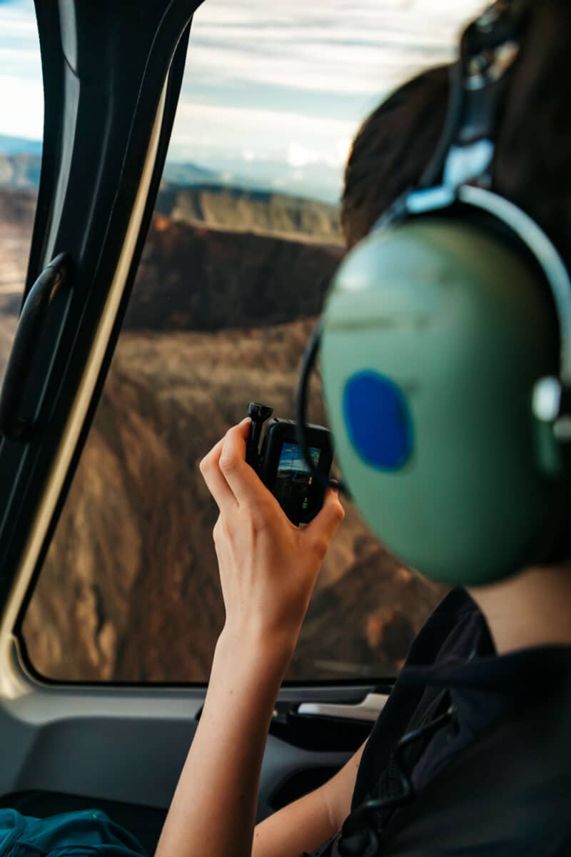 Enfant regardant le paysage par le hublot d’un hélicoptère pendant un survol de La Réunion